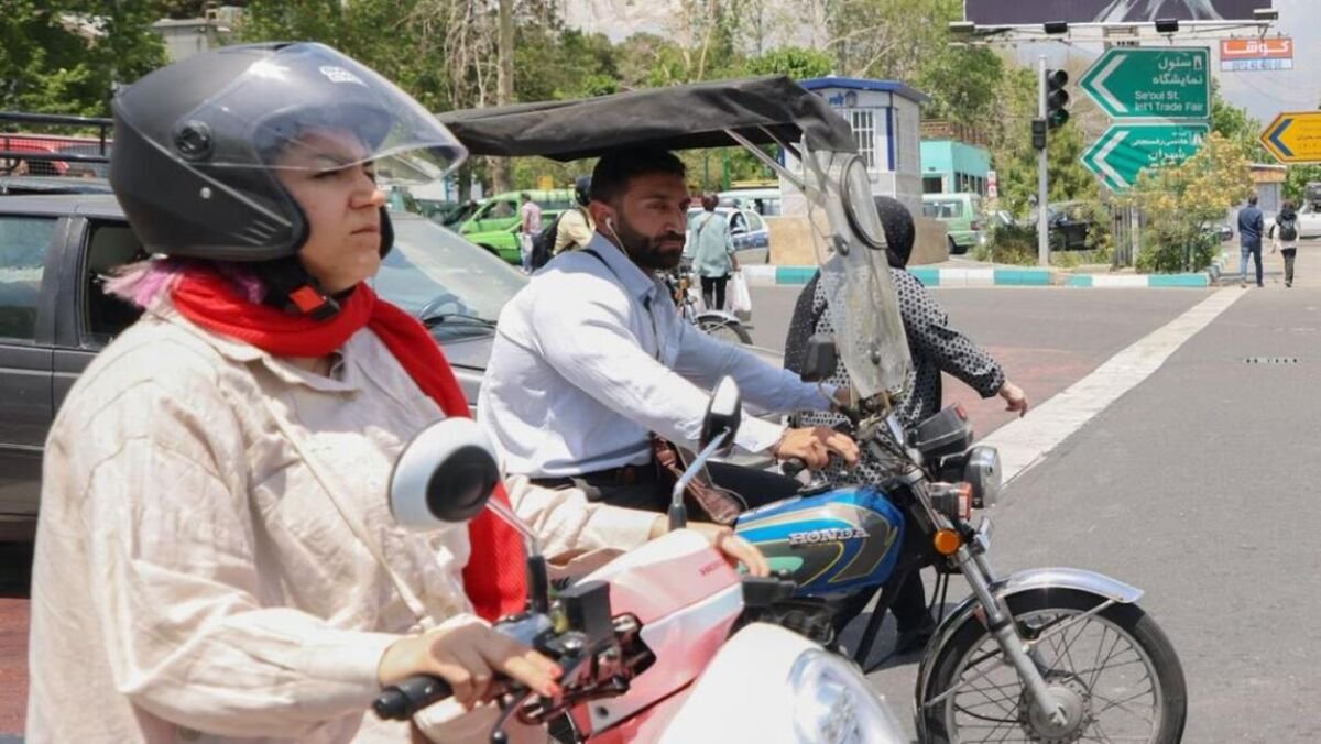 Iranian woman riding a motorcycle in the streets of Isfahan
