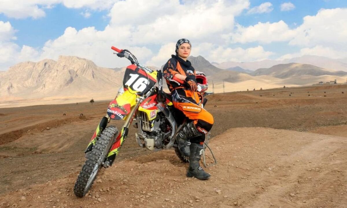 Iranian woman motocross racer on a dirt bike in the mountains